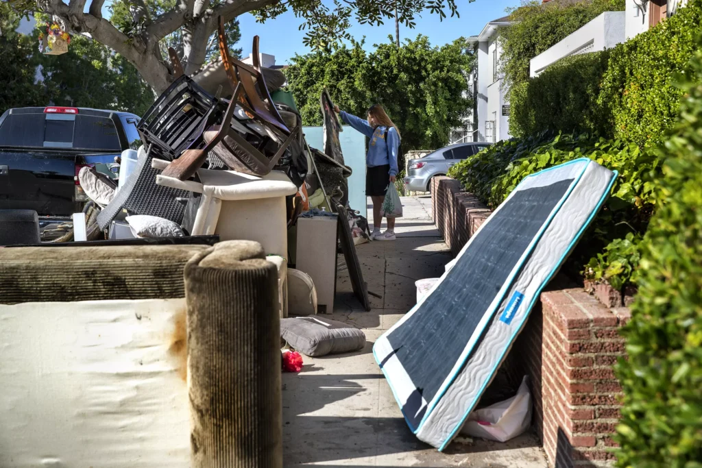 Pile of discarded furniture and mattresses on a residential sidewalk awaiting junk removal